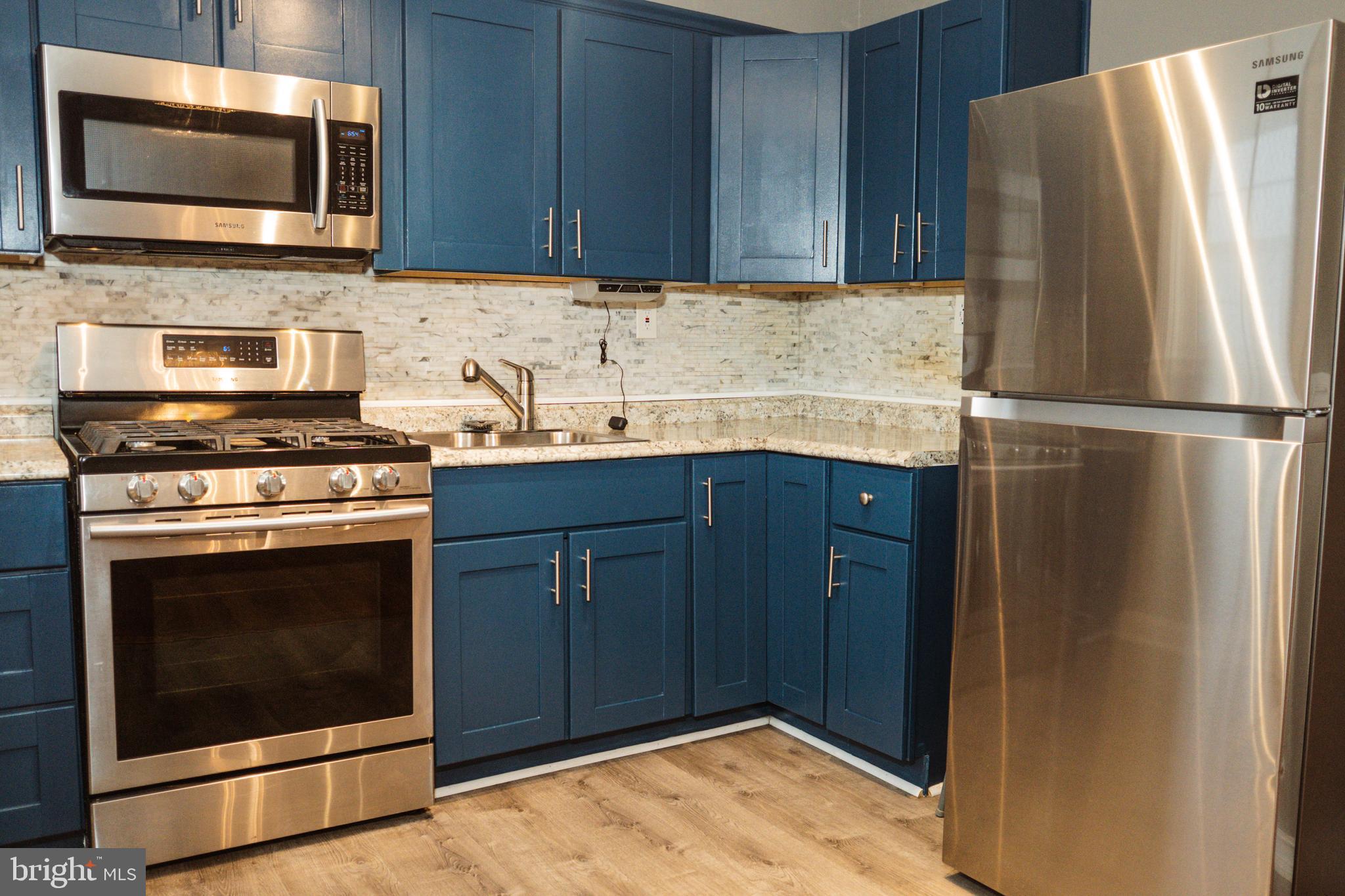 3402 Mayfair Road Baltimore, MD 21207 - Photo 14 of 48 a kitchen with granite countertop a refrigerator stove and microwave