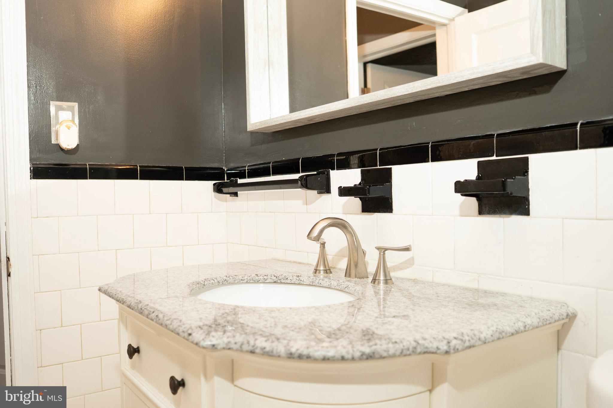 3402 Mayfair Road Baltimore, MD 21207 - Photo 22 of 48 a bathroom with a granite countertop sink