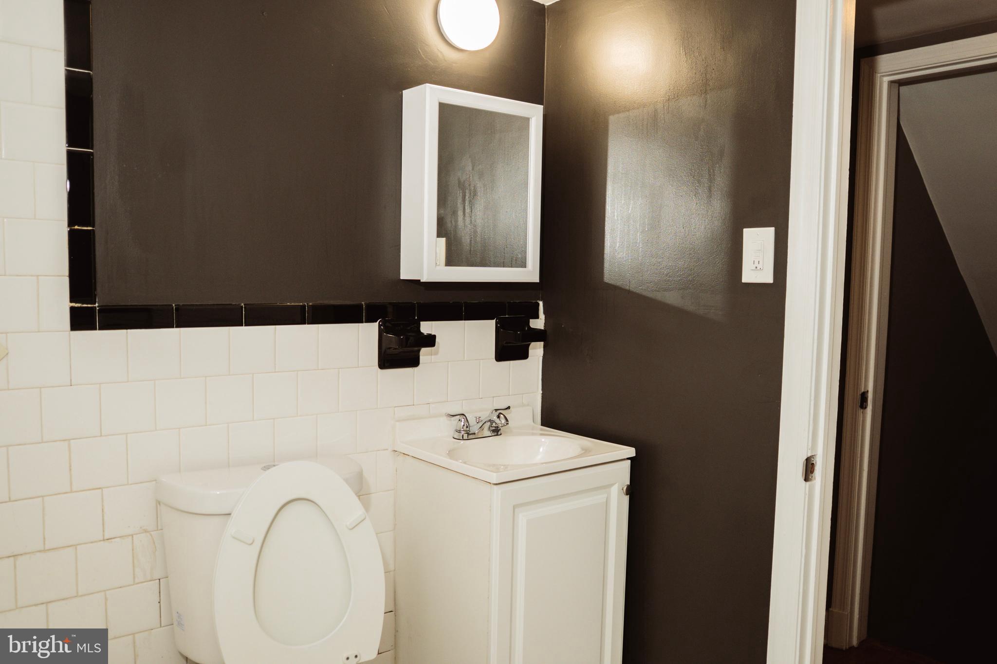 3402 Mayfair Road Baltimore, MD 21207 - Photo 36 of 48 a bathroom with a sink a toilet and mirror