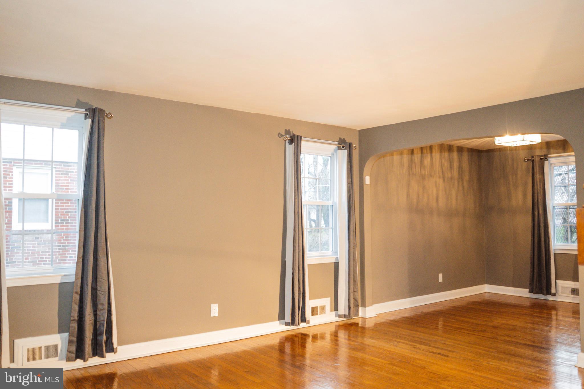 3402 Mayfair Road Baltimore, MD 21207 - Photo 9 of 48 an empty room with wooden floor and windows