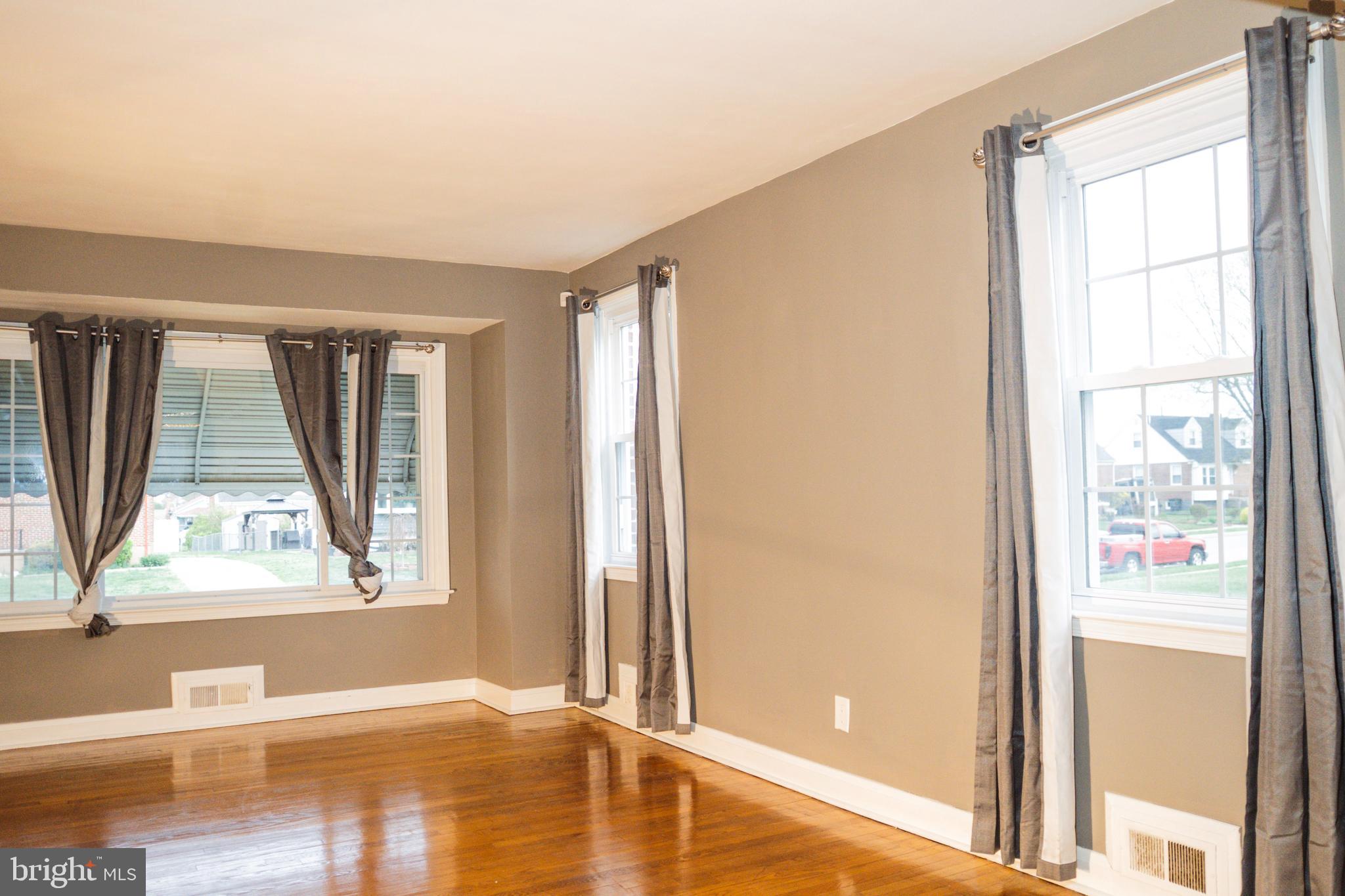3402 Mayfair Road Baltimore, MD 21207 - Photo 10 of 48 a view of a living room with a window and wooden floor
