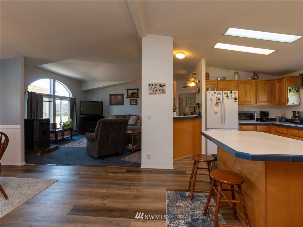 5004 186th Lane Southwest Rochester, WA 98579 - Photo 8 of 27 a kitchen with stainless steel appliances granite countertop a refrigerator a stove a microwave oven a sink with island and chairs