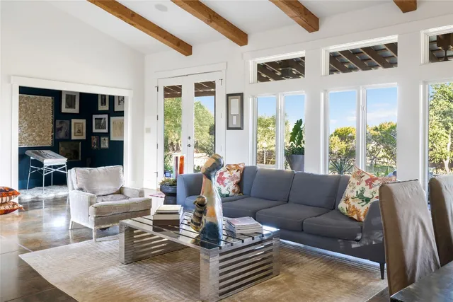 a living room with furniture and large windows