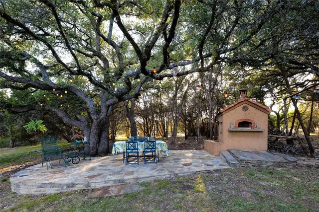 a view of a house with a yard siting and a tree