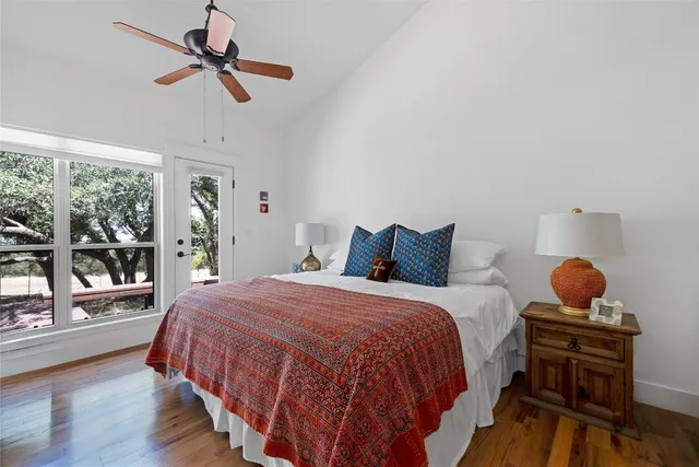 a bedroom with a bed a ceiling fan and a large window