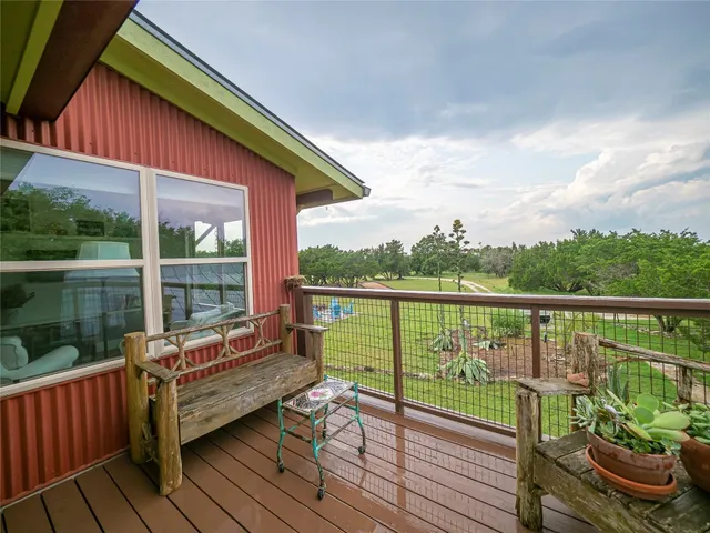 a balcony with wooden floor table and chairs