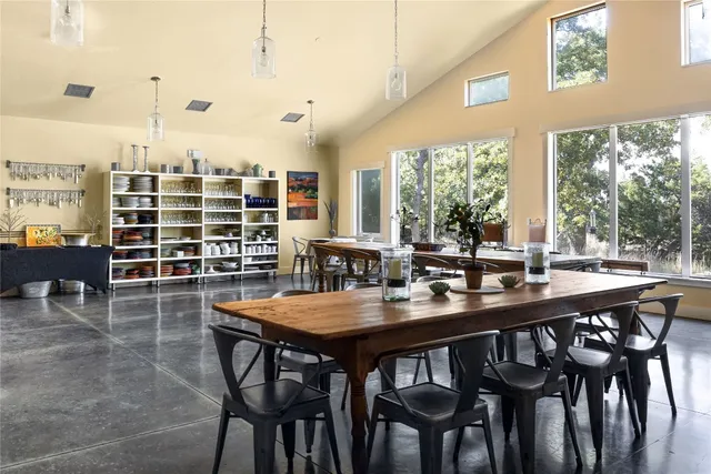 a dining room with stainless steel appliances a table and chairs