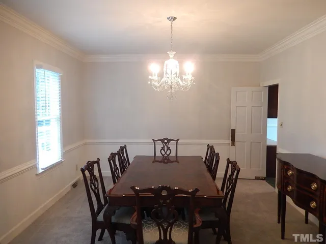 a view of a dining room with furniture and chandelier