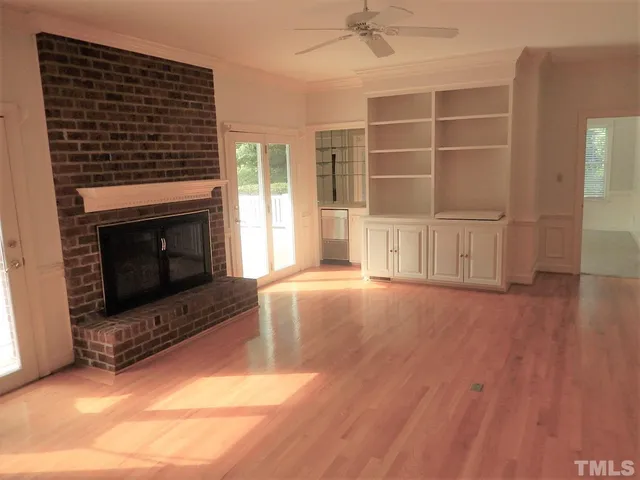 a living room with hard wood floors and a fireplace