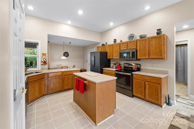a kitchen with stainless steel appliances granite countertop a sink and a refrigerator