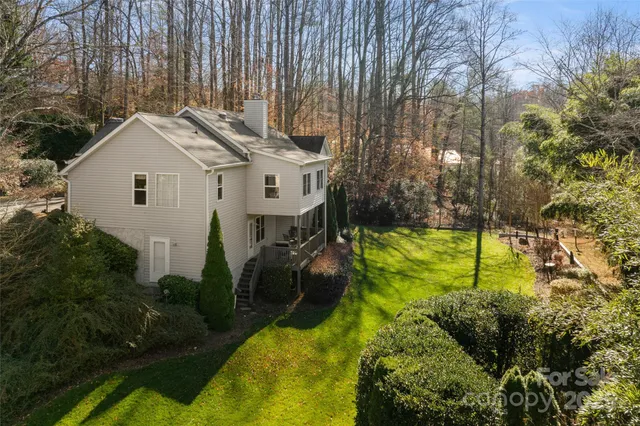 a view of a white house next to a yard