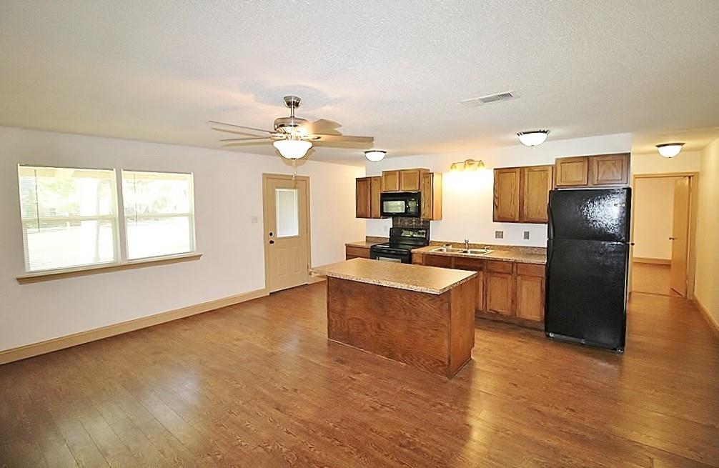 112 Trailwood Road Enchanted Oaks, TX 75156 - Photo 2 of 15 a kitchen with stainless steel appliances granite countertop a refrigerator a sink dishwasher a stove with wooden cabinets and floor