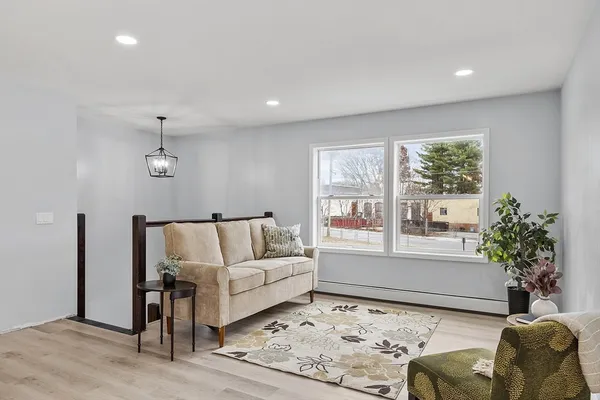 a kitchen with stainless steel appliances granite countertop a stove a sink dishwasher and white cabinets with wooden floor