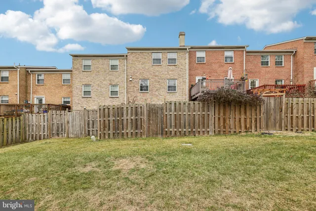 a view of a house with a yard and fence