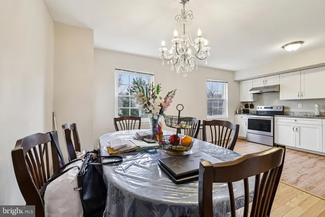 a view of a dining room with furniture a chandelier and window
