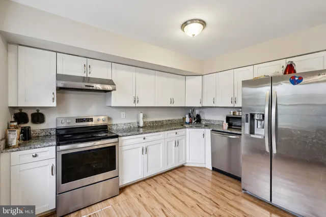 a kitchen with stainless steel appliances granite countertop a stove a refrigerator and a granite counter tops