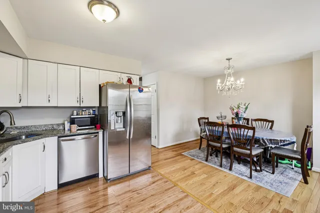 a view of a dining room with furniture a chandelier and wooden floor