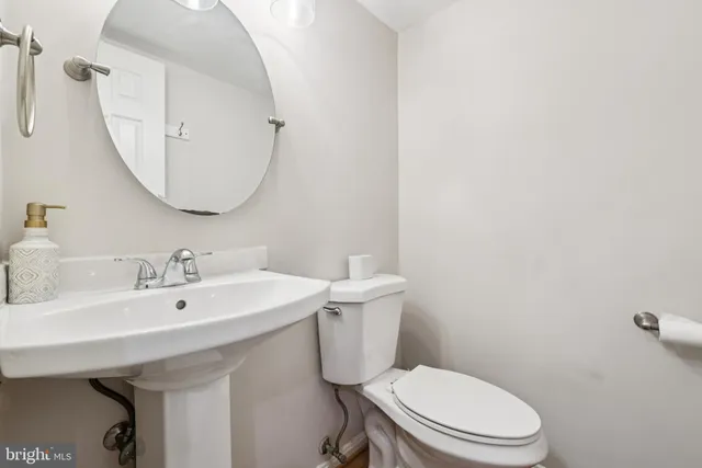 a bathroom with a sink a toilet and mirror