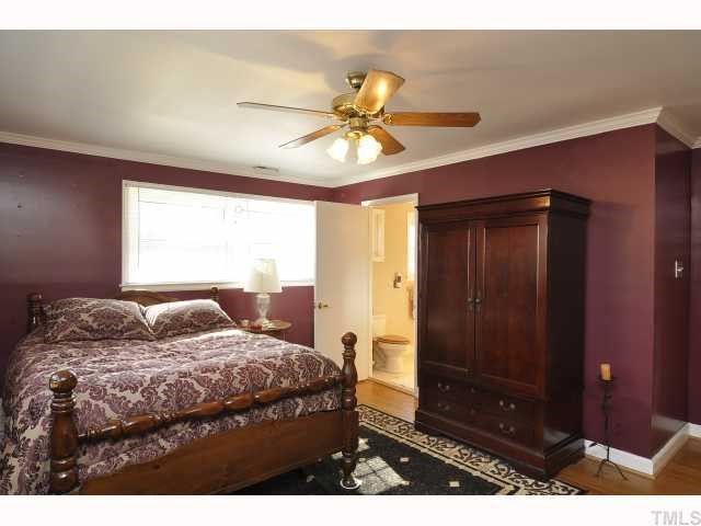 12517 Old Creedmoor Road Raleigh, NC 27613 - Photo 6 of 12 a bedroom with a bed and a chandelier