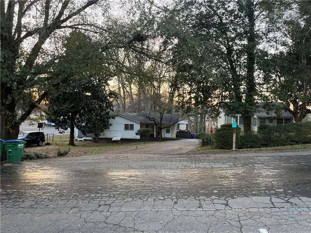 a front view of a house with a yard and trees