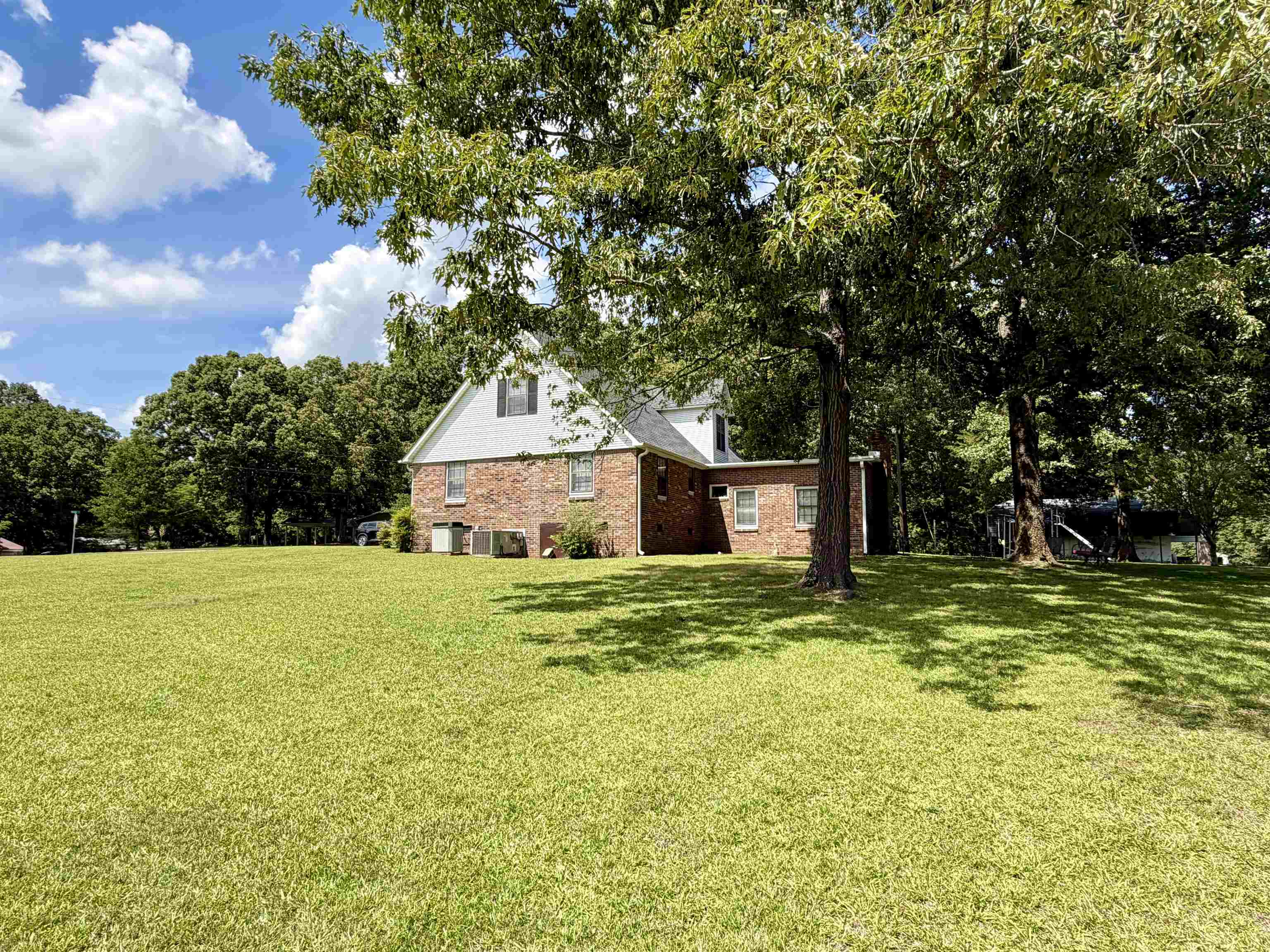 142 Treece Street Selmer, TN 38375 - Photo 30 of 36 Expansive lawn surrounding a brick and siding residence with mature trees