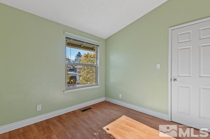1020 Big Springs Road Reno, NV 89523 - Photo 12 of 17 an empty room with wooden floor and windows