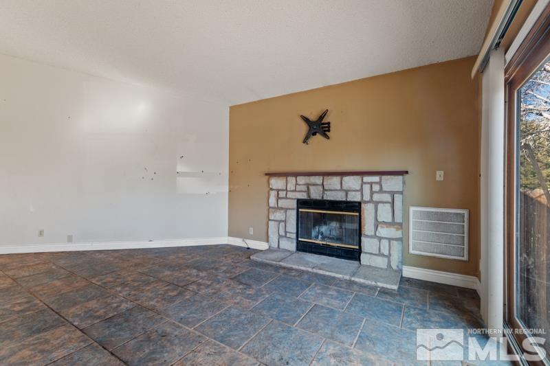 1020 Big Springs Road Reno, NV 89523 - Photo 5 of 17 an empty room with a fireplace and fan