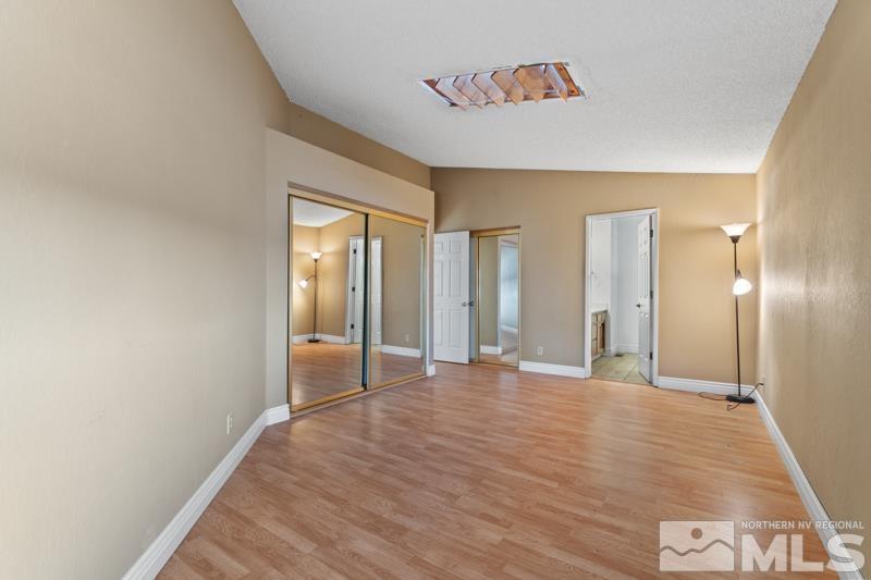 1020 Big Springs Road Reno, NV 89523 - Photo 9 of 17 a view of an empty room with wooden floor and a bathroom