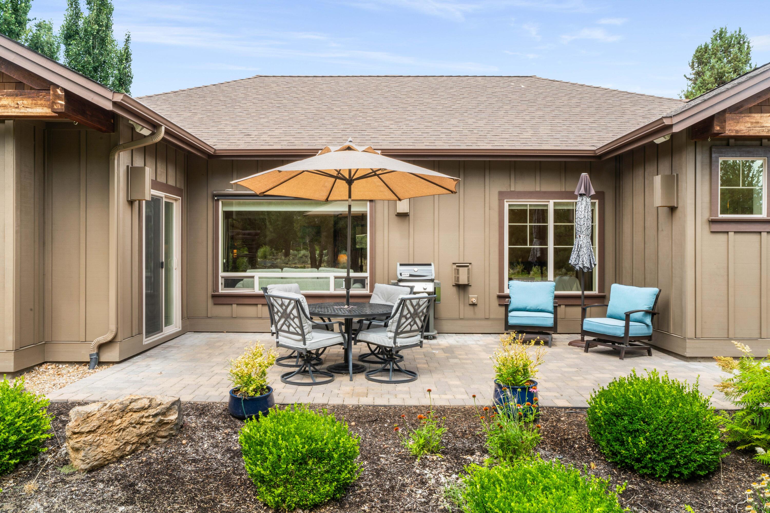 205 Vista Rim Drive Redmond, OR 97756 - Photo 32 of 85 a view of a patio with table and chairs under an umbrella