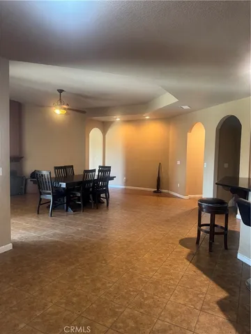 a living room with furniture a dining table a chandelier and a large window