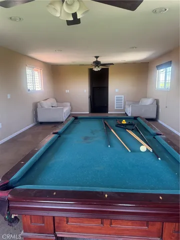 a room with pool table and windows