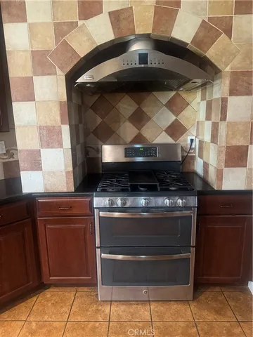 a stove top oven sitting inside of a kitchen