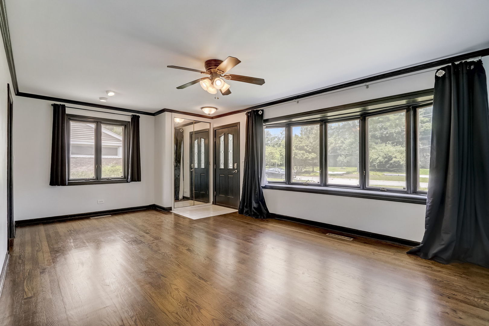 547 East Baldwin Road Palatine, IL 60074 - Photo 3 of 26 a view of an empty room with a window and wooden floor