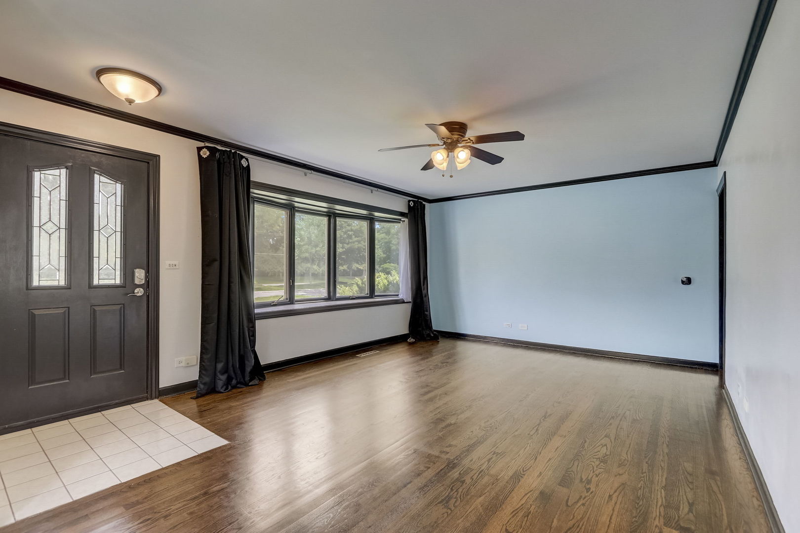 547 East Baldwin Road Palatine, IL 60074 - Photo 4 of 26 a view of an empty room with a window and wooden floor