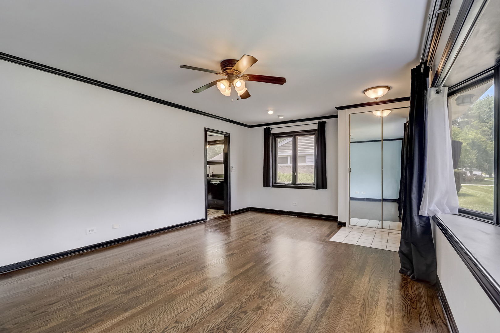 547 East Baldwin Road Palatine, IL 60074 - Photo 5 of 26 a view of an empty room with a window and wooden floor