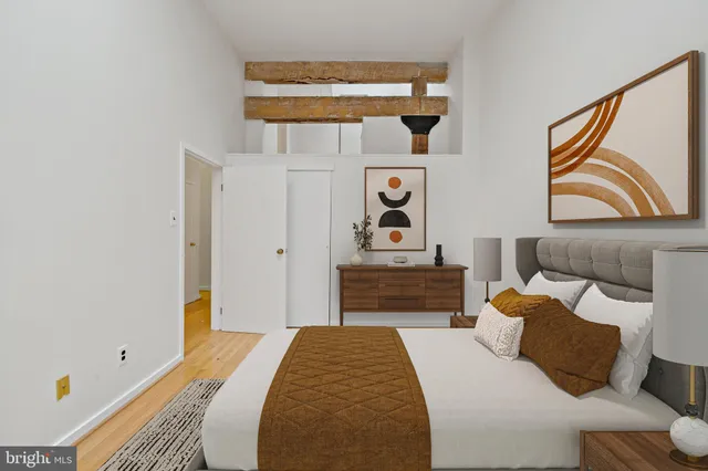 a bedroom with a bed and painting on the wall