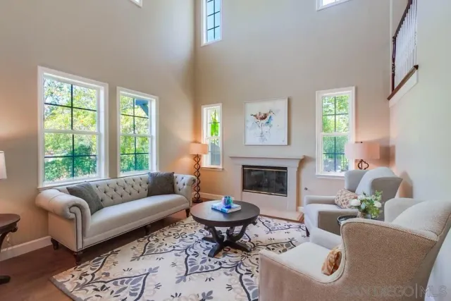 a living room with furniture kitchen view and a chandelier