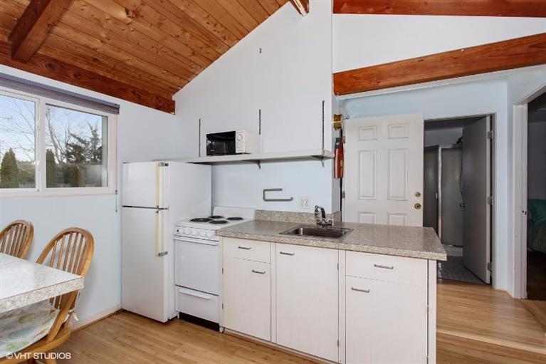 122 Shore Road, Unit 11 Truro, MA 02666 - Photo 5 of 15 a kitchen with granite countertop a sink cabinets and wooden floor