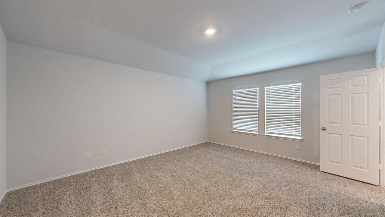557 Hector Loop Georgetown, TX 78626 - Photo 22 of 38 Carpeted room featuring a tray ceiling, recessed lighting, and two windows with blinds