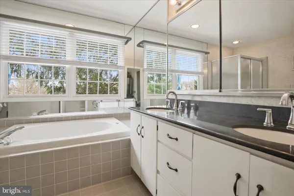 a large kitchen with kitchen island a large window a sink and cabinets