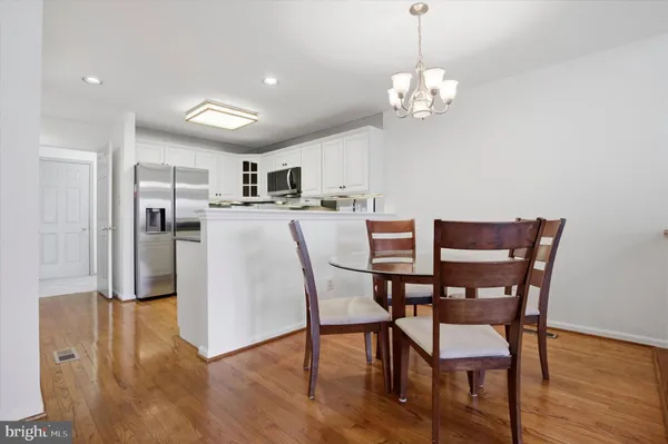 a view of a dining room with furniture a chandelier and wooden floor
