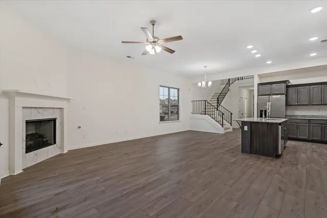 a view of a room with wooden floor a ceiling fan and windows