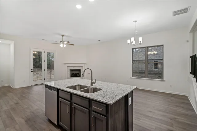 a kitchen with a sink chandelier and wooden floor