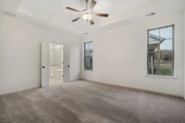 an empty room with fan and windows
