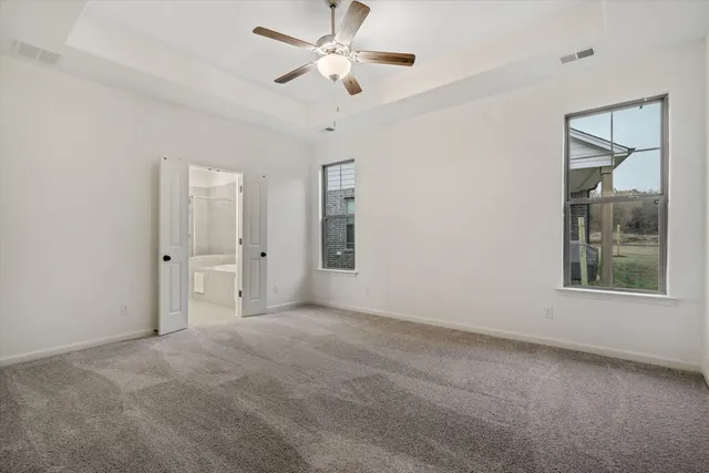 an empty room with fan and windows