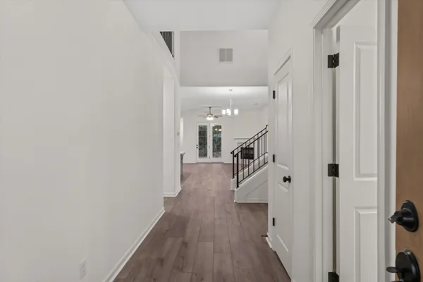 a hallway with wooden floor and staircase