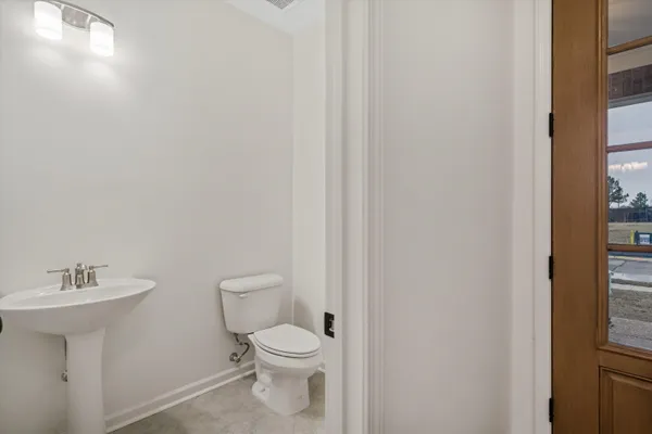 a bathroom with a toilet a sink and a window