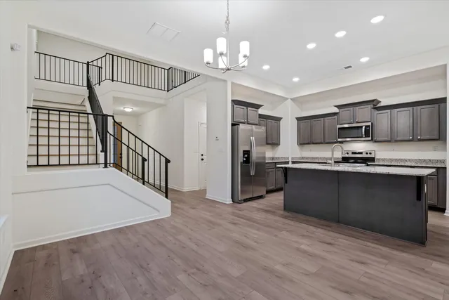 a kitchen with granite countertop a refrigerator and a stove top oven