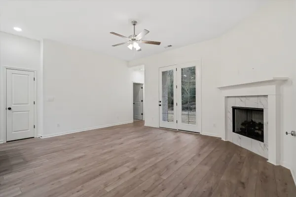 a view of an empty room with a fireplace and a window