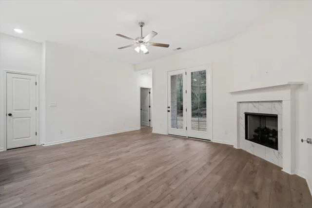 a view of an empty room with a fireplace and a window